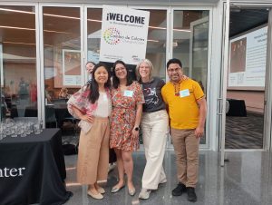 Group of 5 people in front of a WELCOME sign for the conference